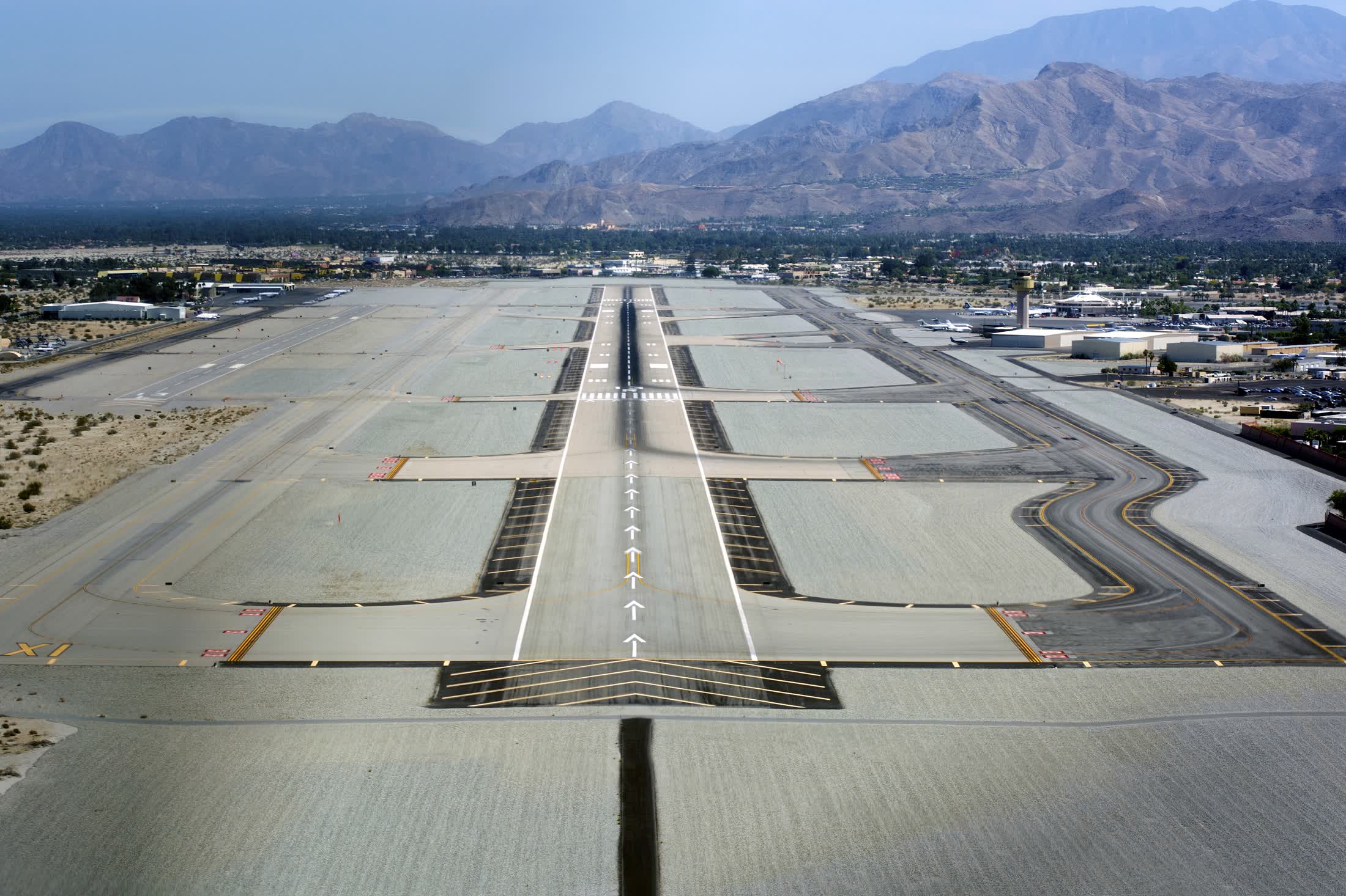 An aerial view of a desert airport with mountains behind